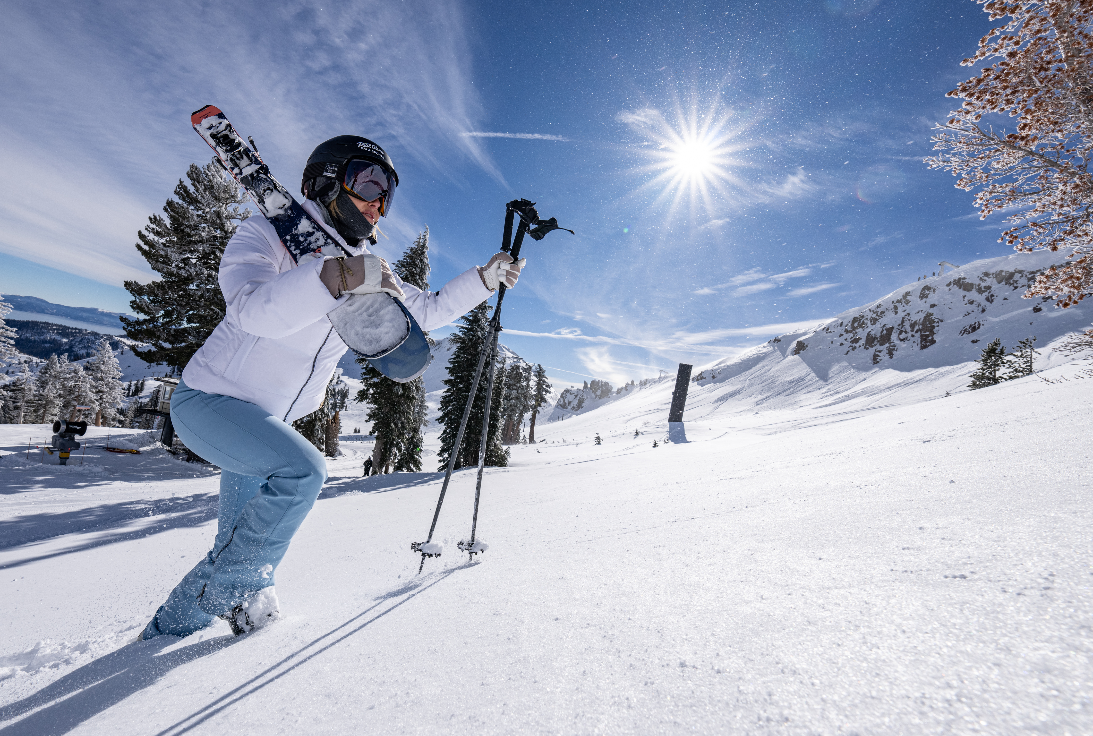 a man hiking up a hill with ski gear