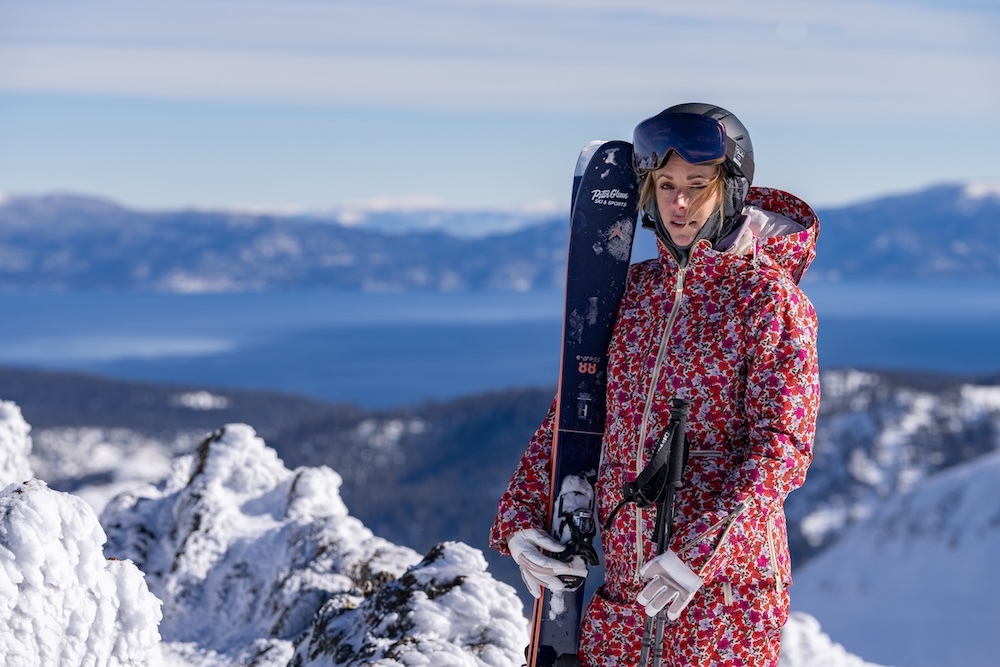 girl on a mountain holding ski